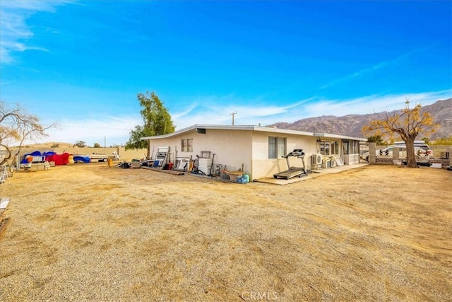 back of house with a mountain view and a yard