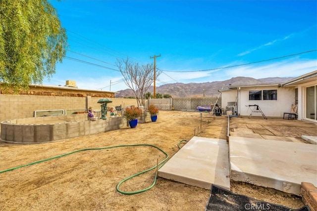 view of yard featuring a mountain view and a patio