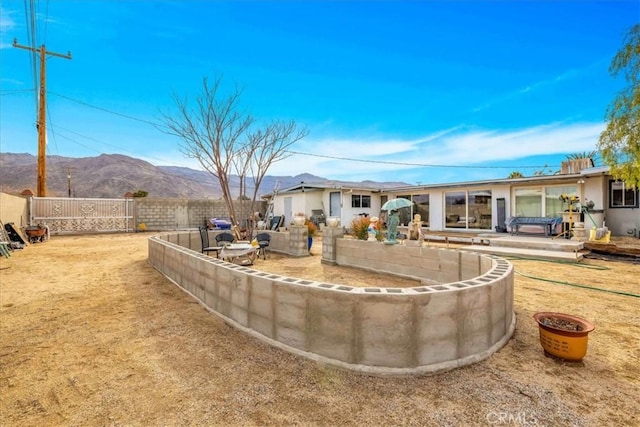 rear view of property featuring a mountain view and a patio area