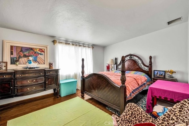 bedroom featuring dark hardwood / wood-style floors and a textured ceiling