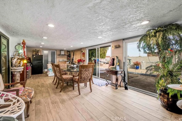 dining area featuring light hardwood / wood-style flooring and a textured ceiling