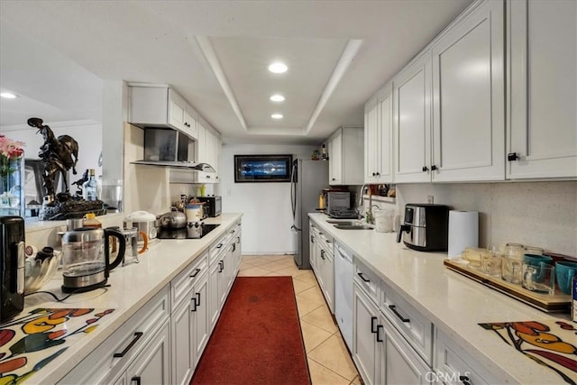 kitchen featuring a raised ceiling, dishwasher, sink, and white cabinets