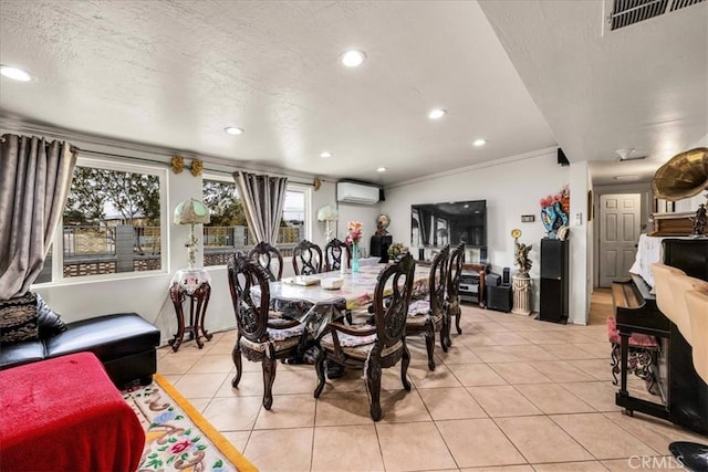 dining room with light tile patterned flooring, ornamental molding, a wall mounted air conditioner, and a textured ceiling