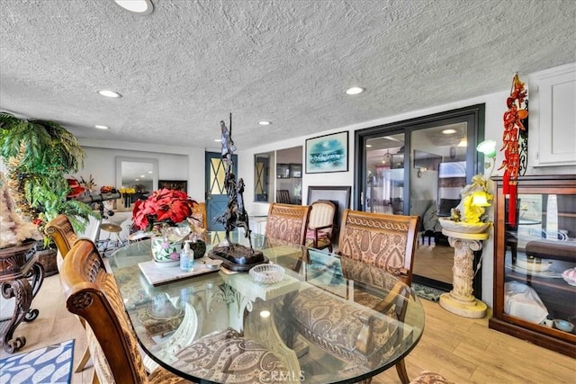 dining room with a textured ceiling and light hardwood / wood-style flooring