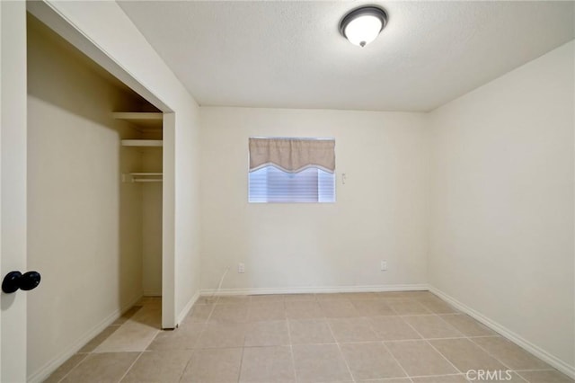 unfurnished bedroom featuring light tile patterned flooring, a closet, and a textured ceiling