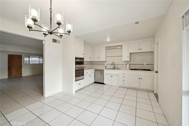 kitchen with pendant lighting, tasteful backsplash, sink, white cabinets, and light tile patterned floors