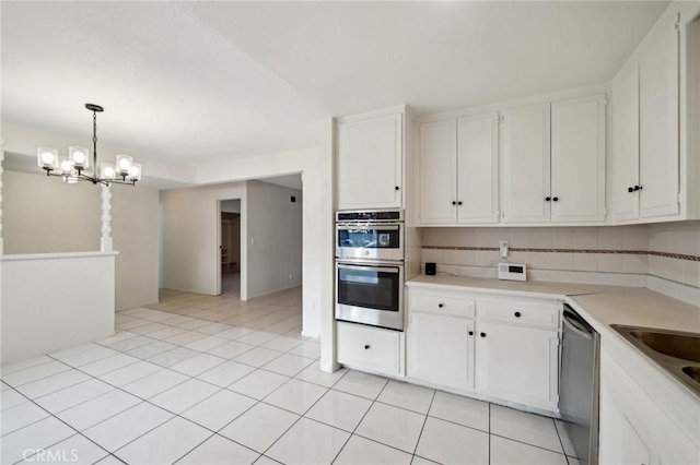 kitchen with white cabinetry, backsplash, and stainless steel appliances