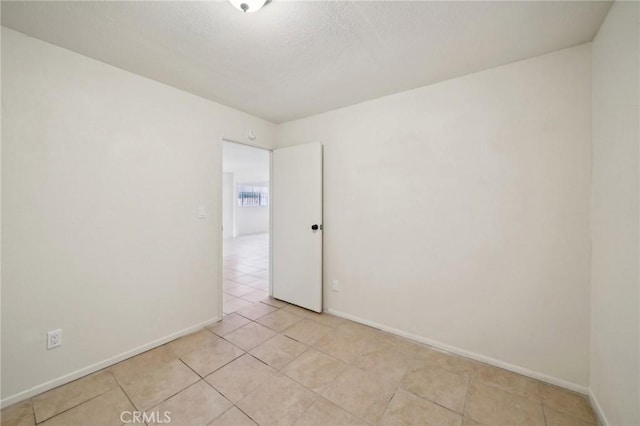 spare room with light tile patterned floors and a textured ceiling