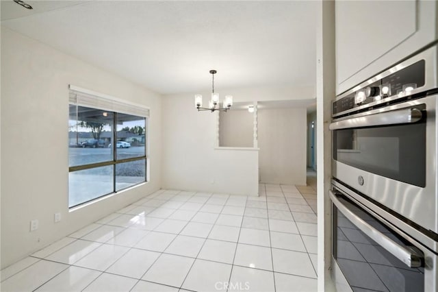 kitchen featuring pendant lighting, an inviting chandelier, light tile patterned flooring, and double oven