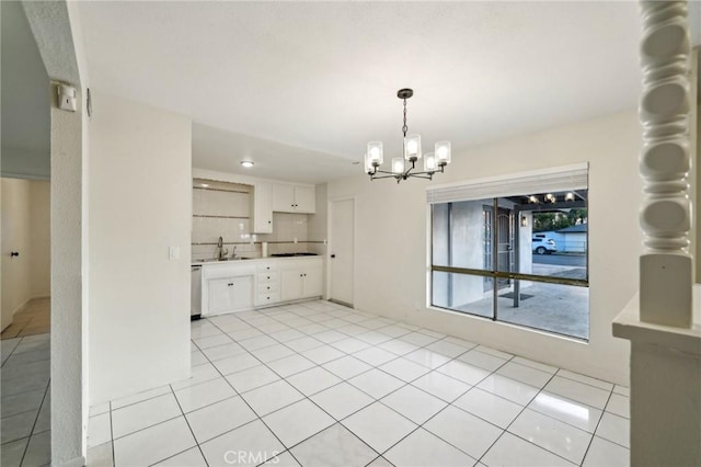 kitchen featuring sink, white cabinetry, an inviting chandelier, light tile patterned floors, and dishwasher