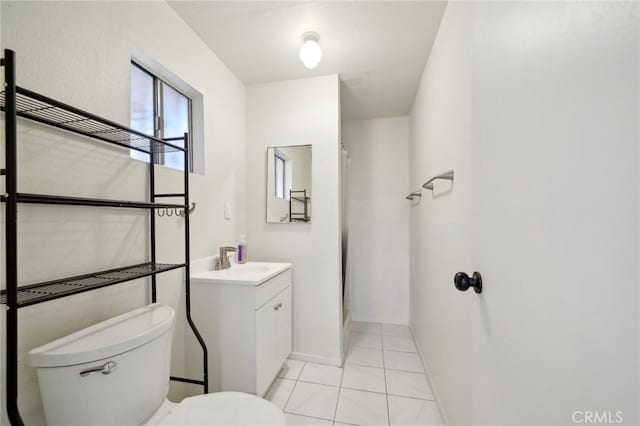 bathroom with vanity, a shower, tile patterned floors, and toilet