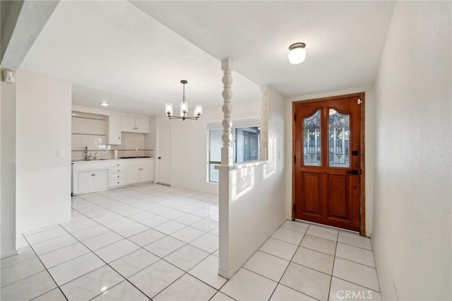 tiled entrance foyer with sink and an inviting chandelier