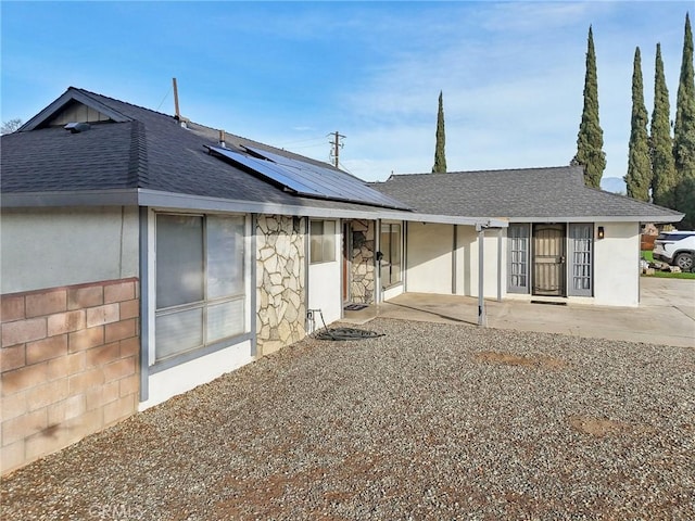 back of property featuring a patio area and solar panels