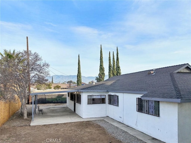 rear view of house with a patio and a mountain view