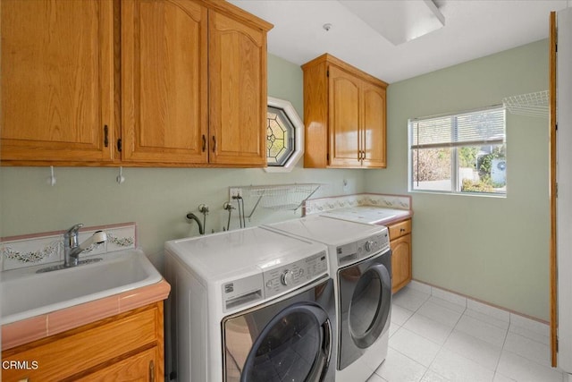 laundry area with cabinets, washer and clothes dryer, and sink