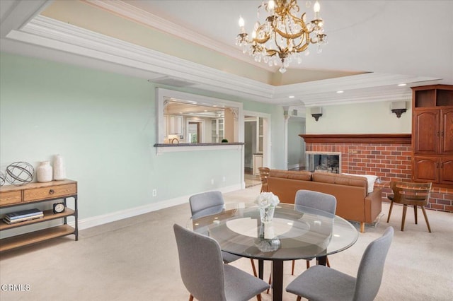 dining space featuring crown molding, a notable chandelier, light carpet, a brick fireplace, and a raised ceiling