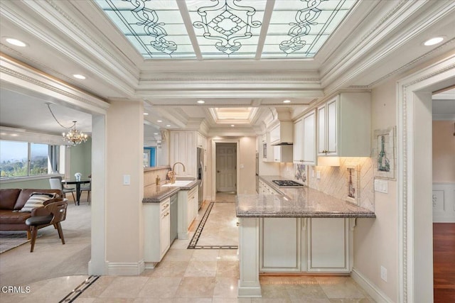 kitchen with sink, appliances with stainless steel finishes, ornamental molding, stone countertops, and kitchen peninsula