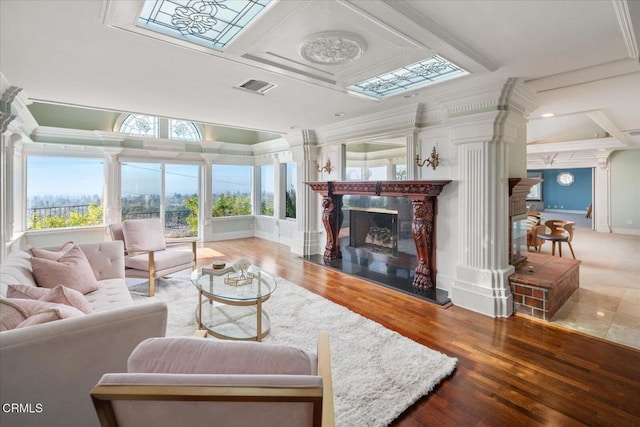 living room featuring ornamental molding, wood-type flooring, a healthy amount of sunlight, and a high end fireplace