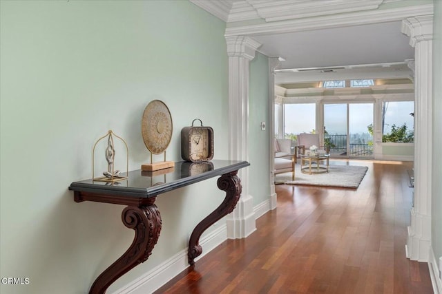 hallway with crown molding, dark wood-type flooring, and ornate columns