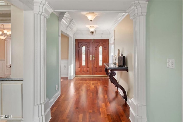 entryway featuring decorative columns, ornamental molding, and wood-type flooring