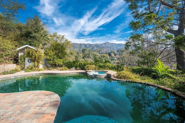 view of swimming pool with an in ground hot tub and a mountain view