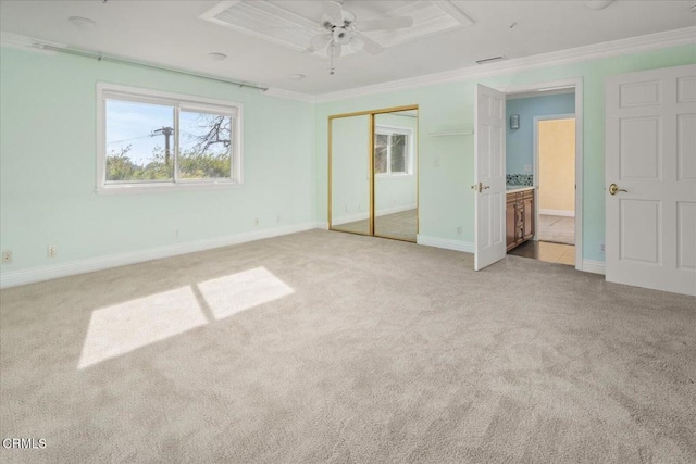 unfurnished bedroom featuring crown molding, light carpet, ceiling fan, and a closet