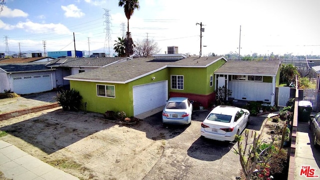 ranch-style house with a garage and central air condition unit