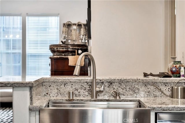 room details with a sink and light stone countertops