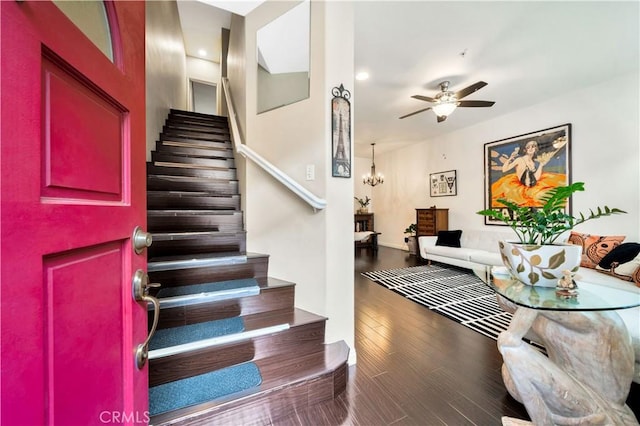 stairway with wood finished floors and ceiling fan with notable chandelier