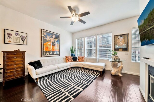 living room with ceiling fan and dark hardwood / wood-style flooring