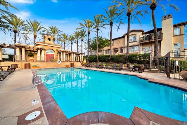 pool featuring fence, a pergola, and a patio