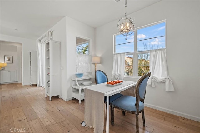 dining area featuring an inviting chandelier and light hardwood / wood-style flooring