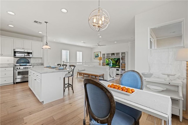 interior space featuring white cabinetry, appliances with stainless steel finishes, and pendant lighting