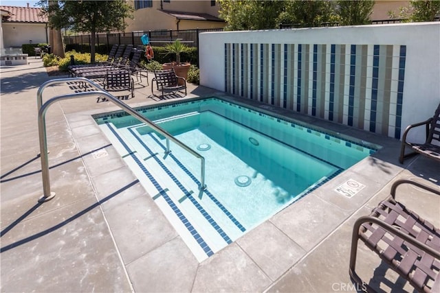 view of pool with a hot tub and a patio area