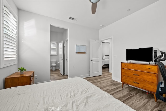 bedroom with light hardwood / wood-style floors and ensuite bath