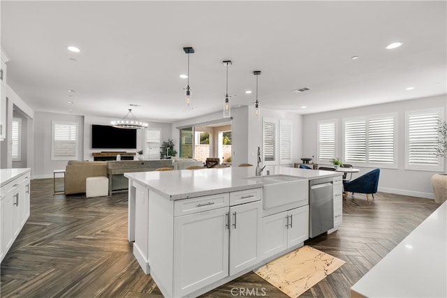 kitchen with sink, white cabinets, dark parquet flooring, a kitchen island with sink, and stainless steel dishwasher