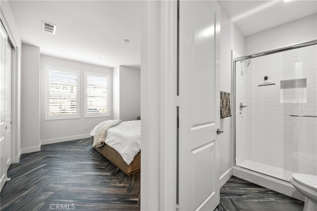 bathroom with parquet floors, toilet, and an enclosed shower