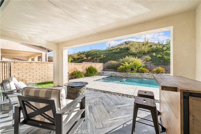 view of patio with a fenced in pool and a fire pit