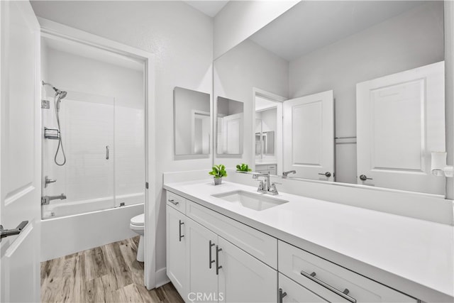 full bathroom featuring vanity, hardwood / wood-style floors, toilet, and washtub / shower combination