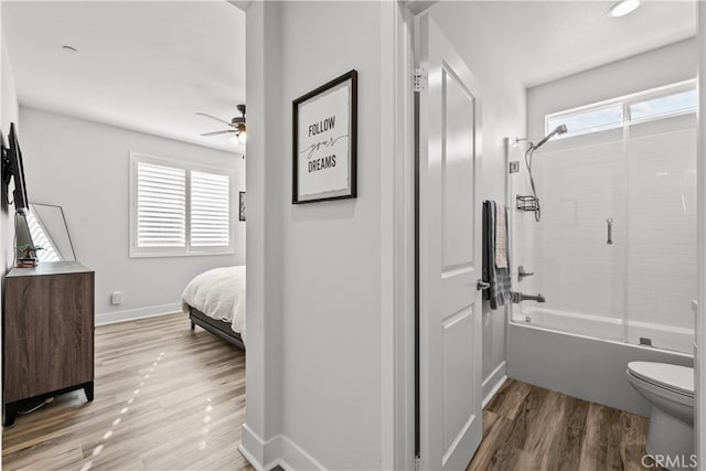 bathroom with bath / shower combo with glass door, plenty of natural light, toilet, and wood-type flooring