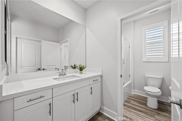 full bathroom featuring hardwood / wood-style flooring, vanity, toilet, and shower / tub combination