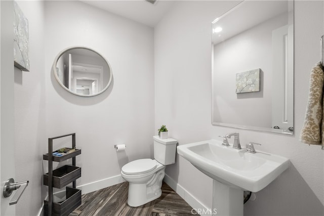 bathroom with hardwood / wood-style flooring, sink, and toilet