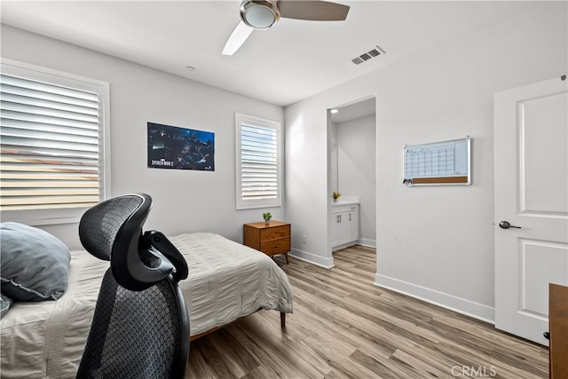 bedroom featuring ceiling fan, ensuite bathroom, and light hardwood / wood-style flooring