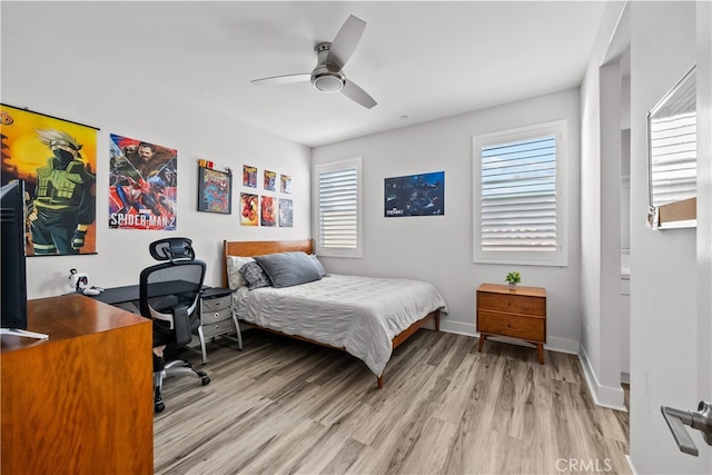 bedroom with multiple windows, light hardwood / wood-style floors, and ceiling fan