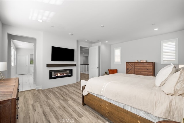 bedroom featuring ensuite bathroom and light hardwood / wood-style floors