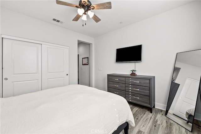 bedroom featuring ceiling fan, a closet, and light wood-type flooring