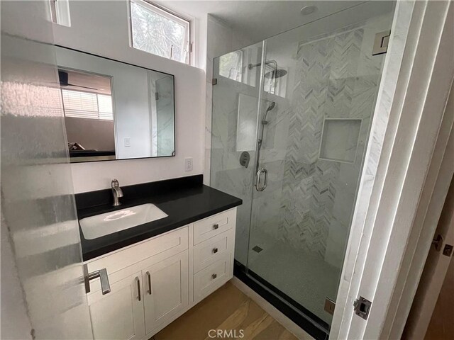 bathroom featuring walk in shower and vanity