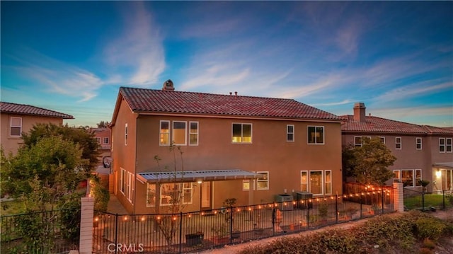 back house at dusk featuring a pergola