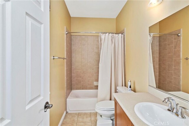 full bathroom featuring shower / bathtub combination with curtain, vanity, tile patterned floors, and toilet