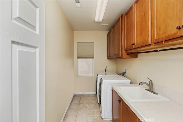 laundry area featuring cabinets, light tile patterned flooring, sink, and independent washer and dryer